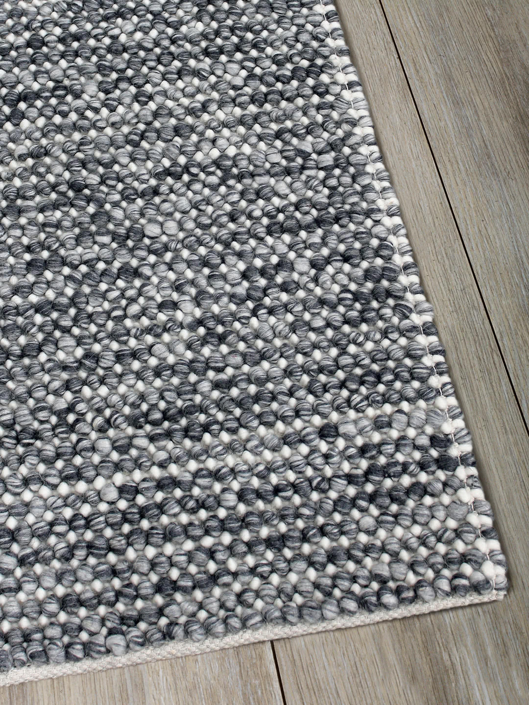 Magic Storm charcoal grey textured rug handwoven in wool - corner image
